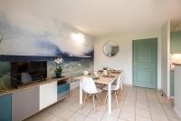 a kitchen with a table and chairs and a tv at Belle Dune in Fort-Mahon-Plage