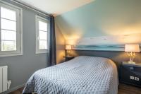 a bedroom with a bed and two windows at Belle Dune in Fort-Mahon-Plage