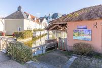 a building with a sign on it next to a river at Belle Dune in Fort-Mahon-Plage