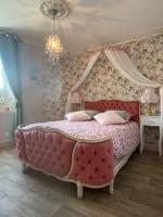 a bedroom with a pink bed with a canopy at Le Moulin du Modon in Couffy