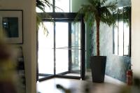 a potted palm tree in a room with a glass door at Hôtel Mar I Cel &amp; Spa in Canet-en-Roussillon