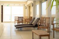 a waiting room with wooden chairs and windows at Hôtel Mar I Cel &amp; Spa in Canet-en-Roussillon