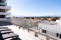 a balcony with chairs and a view of a city at Hôtel Mar I Cel &amp; Spa in Canet-en-Roussillon