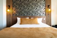 a bedroom with a bed with a large headboard at Hôtel Mar I Cel &amp; Spa in Canet-en-Roussillon