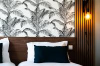 a bedroom with a bed with a black and white wallpaper at Hôtel Mar I Cel &amp; Spa in Canet-en-Roussillon