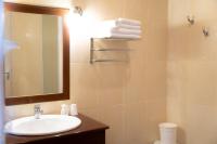 a bathroom with a sink and a mirror and towels at Hôtel Mar I Cel &amp; Spa in Canet-en-Roussillon