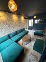 - un salon avec des canapés bleus et un mur en briques dans l&#39;établissement L&#39;ATELIER DU VIEUX BOIS Spa, à Bayeux