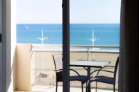 a table and chairs on a balcony with a view of the ocean at Hôtel Mar I Cel &amp; Spa in Canet-en-Roussillon