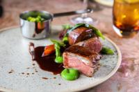 a plate of food with meat and vegetables on a table at Burleigh Court Hotel in Stroud