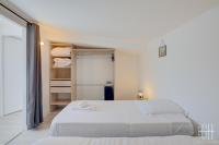 a white bedroom with two beds and a closet at HALTE 3 &#47; GUÈS DE VEIGNE in Veigné