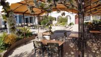 an outdoor patio with tables and chairs and a fountain at Hotel Carmel in Les Vans