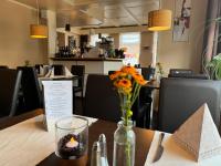 a table with a vase of flowers and a candle on it at Alte Schmiede Hotel & Restaurant in Jork