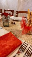 un tavolo con un tovagliolo rosso e una forchetta e un coltello di Agriturismo Il Campagnino a Cremona