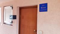a door with a blue sign on the side of a building at Apartment Kodi in Privlaka