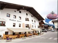 a large white building with benches in front of it at Hotel & Apart Central in Fügen