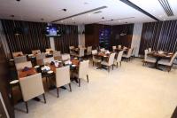 uma sala de jantar com mesas e cadeiras em um restaurante em City Tower Hotel em Fujairah