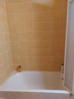 a bathtub in a bathroom with orange tiles at Les Airelles 33, Le coin, Molines en Queyras Classé 3 étoiles in Molines-en-Queyras