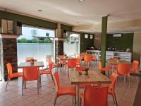 Un restaurante con mesas y sillas y una cocina. en Hotel Catur Putra, en Magelang