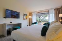 a hotel room with a large bed and a window at Golf Hôtel de Valescure &amp; Spa NUXE in Saint-Raphaël