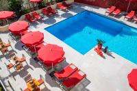 an overhead view of a pool with red umbrellas and chairs at Hotel Carlton in Beaulieu-sur-Mer