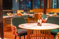 un ristorante con sedie e un tavolo con un tovagliolo sopra di SKI Hotels and Resorts Rishikesh a Rishikesh