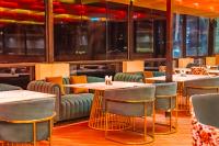 un ristorante con tavoli, sedie e finestre di SKI Hotels and Resorts Rishikesh a Rishikesh