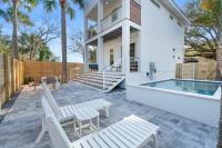 eine Terrasse mit weißen Stühlen und einem Pool in der Unterkunft Sunset Cove - Heated Pool - Sea Views - Walkable in St. Augustine