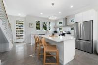 eine weiße Küche mit einer Insel mit Stühlen und einem Kühlschrank in der Unterkunft Sunset Cove - Heated Pool - Sea Views - Walkable in St. Augustine