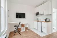 a kitchen with white cabinets and a chair in it at Studette 4 calme et Lumineux, entièrement équipée in Créteil