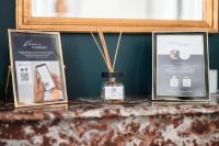 a table with a bottle of essential oil and two pictures at L&#39;Orée du Faubourg - VENDOME CENTRE in Vendôme