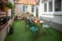 a table and chairs on a balcony with green grass at L&#39;Orée du Faubourg - VENDOME CENTRE in Vendôme