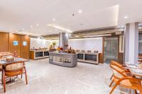cocina grande con paredes de madera, mesas y sillas en Regenta Inn Gurugram Sec-47 City Center, en Gurgaon