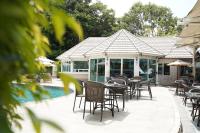 Pattaya Discovery Beach Hotel - SHA Extra Plus في باتايا سنترال: فناء به طاولات وكراسي بجانب مسبح