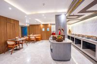 una cocina con mesas, sillas y una barra en Regenta Inn Gurugram Sec-47 City Center, en Gurgaon