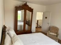 a bedroom with a bed and a mirror and a chair at Maison d hôtes Les Chantours dans réserve naturelle 15 hectares in Saint-Antoine-Cumond