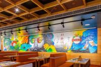 un mural en la pared de un restaurante con mesas en Hotel Tamarind, en Sohāna