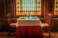 ein Tisch mit einer Tischdecke darauf und einem Buntglasfenster in der Unterkunft Hotel Náyade in Los Ángeles de San Rafael