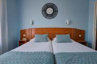 a bedroom with two beds and a mirror on the wall at Brit Hotel Europ Bergerac in Bergerac