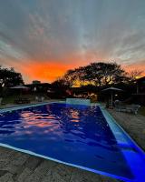 Una gran piscina azul con una puesta de sol al fondo en Los Cruxes, en Tepoztlán