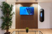 eine Lobby mit einem TV an der Wand mit Pflanzen in der Unterkunft סוויטות אוראל 432 in Eilat