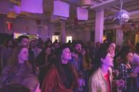 Un grupo de personas de pie entre una multitud en una habitación. en Auberge de Jeunesse des Balcons, en Baie-Saint-Paul