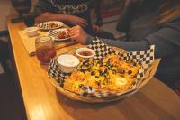 Una canasta de comida sobre una mesa de madera en Auberge de Jeunesse des Balcons, en Baie-Saint-Paul
