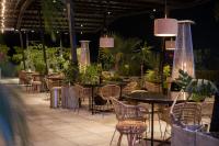 an outdoor patio with tables and chairs and plants at FR Hotel in Ibagué