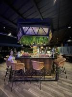 a bar with chairs and a woman sitting at it at FR Hotel in Ibagué