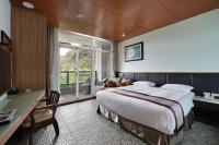 a hotel room with a bed and a desk and a window at Shante Hotel Shitou in Lugu Lake