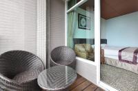 a patio with two wicker chairs and a glass table at Shante Hotel Shitou in Lugu Lake