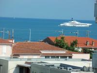 a cruise ship in the water with buildings at Appartement vue mer accès plage in Antibes