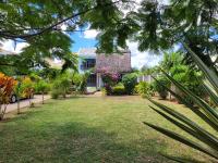 un jardín frente a una casa con flores en Villa Kayana, en Flic en Flac