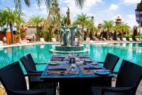 莱卡邦阿玛塔兰达度假村的泳池前的一张桌子旁摆放着一座雕像