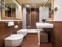 a bathroom with two sinks and a toilet and a shower at Hotel Papadopoli Venezia - MGallery Collection in Venice